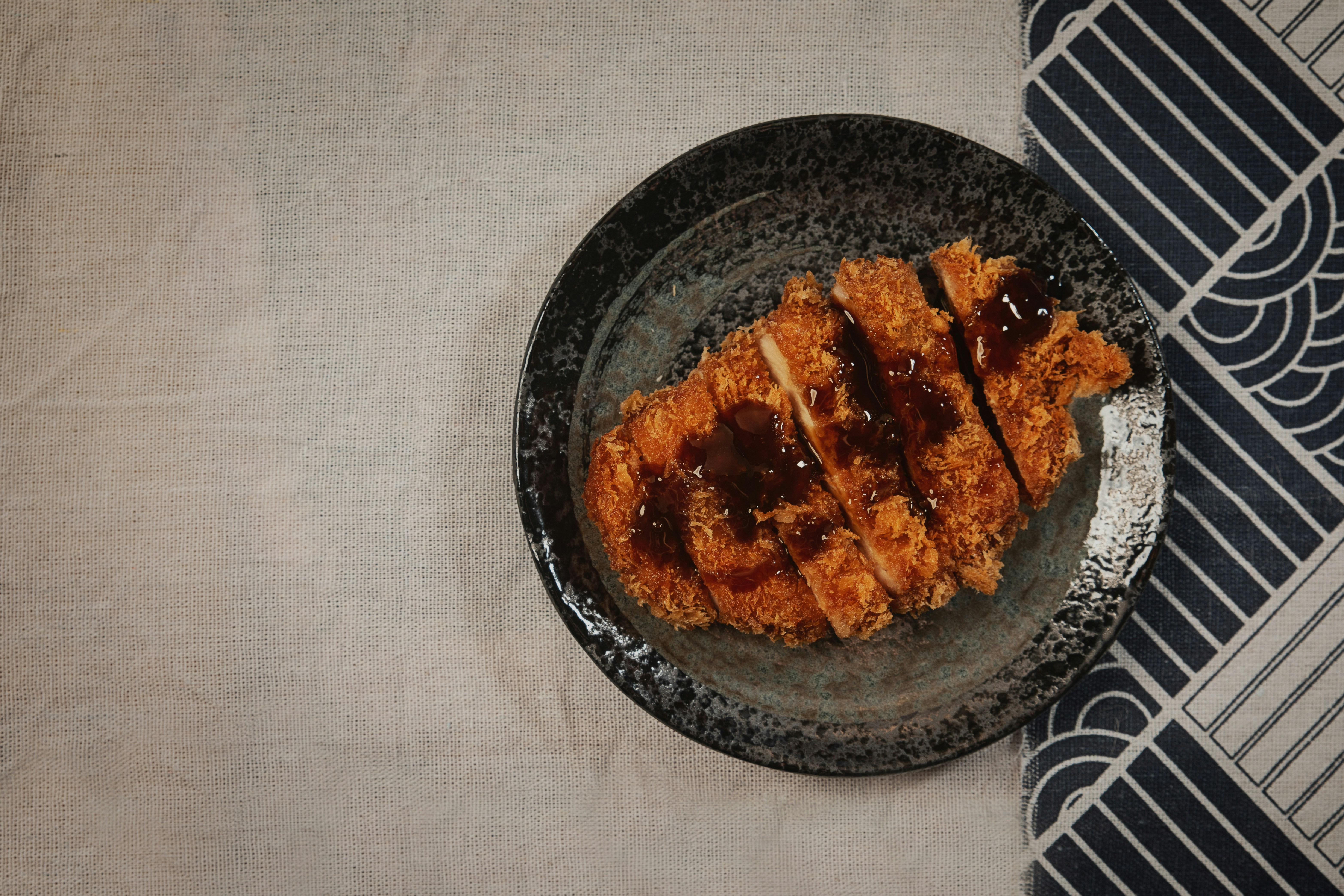 スーパーマーケットの野菜コーナーで、緑黄色野菜やきのこ類を選んでいる手の写真