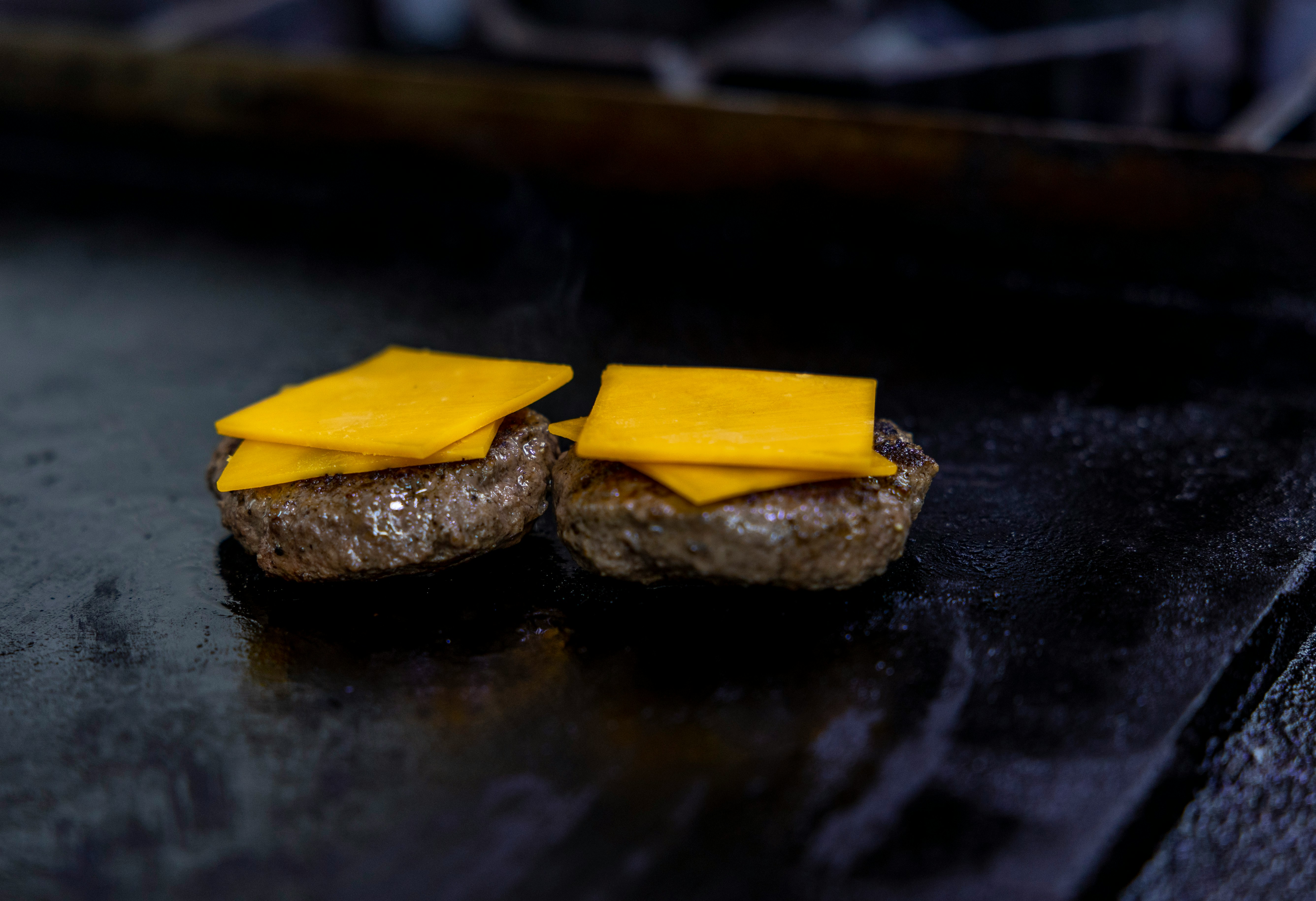 薄暗い部屋で、お気に入りの音楽を聴きながら、燻製おつまみとお酒を楽しんでいるリラックスした雰囲気の写真