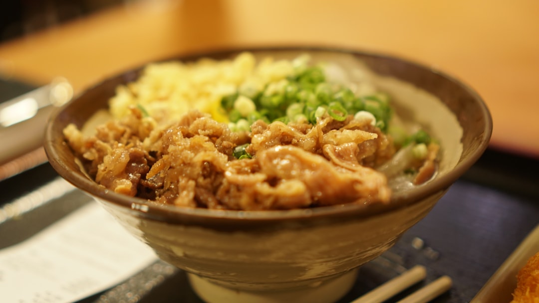 家族や友人が集まって、食卓を囲み、マグロ丼を美味しそうに食べている風景