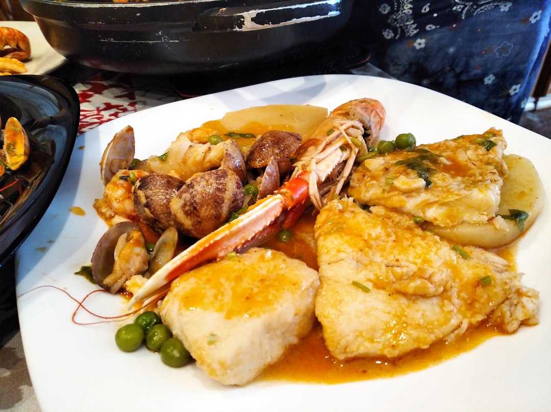 炙ったエイヒレに柚子胡椒マヨネーズが添えられ、日本酒のグラスが横に置かれている写真